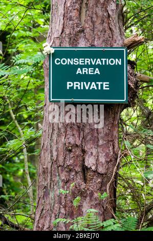 Zone de conservation, privée, panneau fixé à un arbre dans une zone forestière pour protéger une zone réservée à la conservation de la faune. Banque D'Images