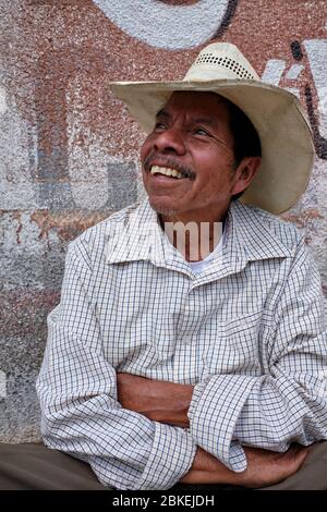 Portrait d'un homme d'âge moyen avec chapeau de cowboy assis à la porte de sa maison à Amatenango del Valle. Banque D'Images