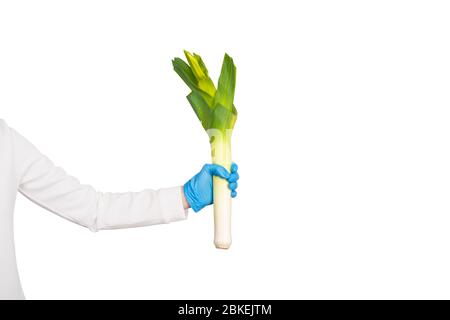 La main femelle dans un gant jetable tient le poireau. L'hygiène dans la cuisine concept. Copier l'espace Banque D'Images