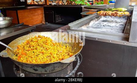 Pilaf ouzbek savoureux dans un chaudron en plein air au festival de la nourriture de rue. Banque D'Images