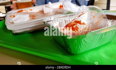 Restes de nourriture, plats en plastique sales sur un plateau vert sur une table dans un café extérieur. Banque D'Images