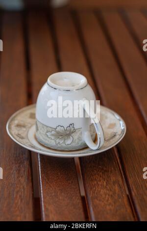 Renversée en tasse de café turc sur soucoupe traditionnellement en utilisant pour dire de fortune sur table en bois, dire de fortune de café Banque D'Images