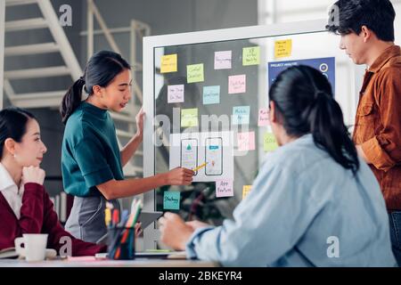 développeur et concepteur d'interface utilisateur d'ux asiatique présentant la conception d'interface d'application mobile sur tableau blanc en réunion dans un bureau moderne.développement numérique créatif mobil Banque D'Images