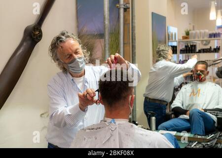 Salon de coiffure à Essen-Rüttenscheid, premier client après 6 semaines, magasin fermé en raison de la crise de Corona, maître de coiffure et client avec bouche n Banque D'Images