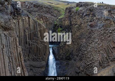 La superbe cascade de Litlanesfoss où l'eau tombe entre la géologie massive de la colonne de basalte, l'Islande. Banque D'Images