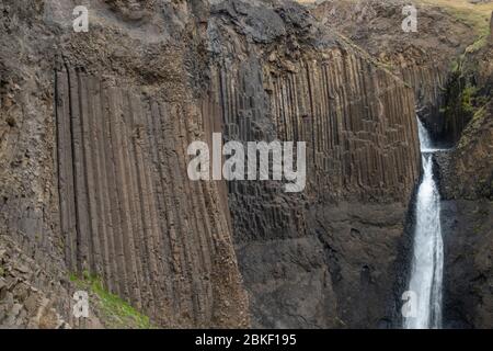 Détail de la géologie massive de la colonne de basalte de la superbe cascade de Litlanesfoss, où l'eau tombe entre, l'Islande. Banque D'Images