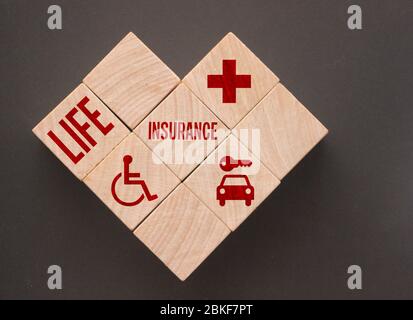 Mots et icônes d'assurance vie sur des cubes en bois. Le concept intelligent de soins de santé, d'assurance, symbolise l'assurance pour protéger et couvrir les risques de blessures Banque D'Images