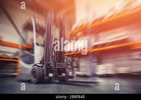 Entrepôts locaux industriels pour le stockage de matériaux et de bois, conteneurs de chariots élévateurs. Concept logistique, transport. Effet de flou de mouvement. Lumière du soleil vive. Banque D'Images
