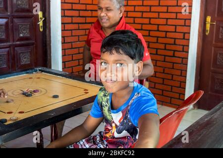 Les familles qui essaient de garder la vie aussi normale que possible. Jouer à des jeux de société à la maison parce que le couvre-feu et le verrouillage sont imposés dans le pays. Colombo, Sri Lanka. Banque D'Images