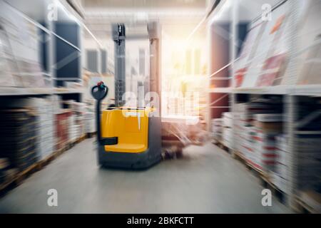 Entrepôts locaux industriels pour le stockage de matériaux et de bois, chariots élévateurs pour conteneurs. Concept logistique, transport. Effet de flou de mouvement. Un soleil éclatant Banque D'Images