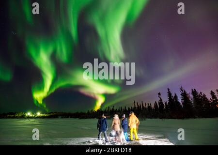 Compagnie d'amis touriste regarde les lumières du nord à la forêt de bord. Effet flou de flou de mise au point douce Banque D'Images