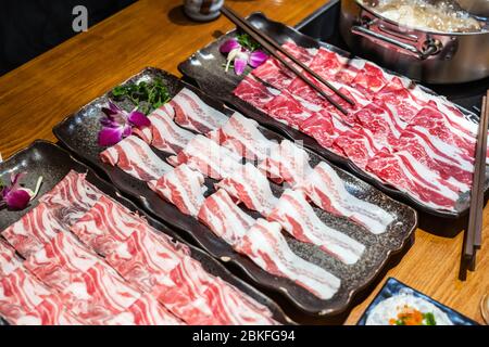 Sélection de plats de viande à cuire dans le restaurant Hotpot, y compris le bœuf, l'agneau et le porc. Toutes les tranches fines pour une cuisson rapide Banque D'Images