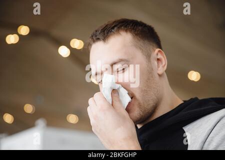 L'homme souffle sur le foulard et la toux, élimine le mucus. Concept grippe, froid en hiver. Banque D'Images