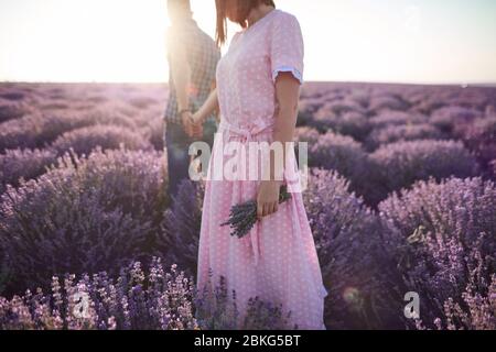 couple dans la marche d'amour dans les beaux champs de fleurs Banque D'Images