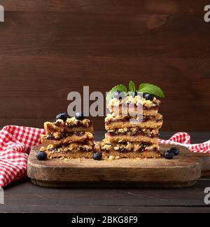 pile de tranches carrées de tarte aux crumettes cuites avec de la prune bleue sur un panneau en bois, délicieux dessert Banque D'Images