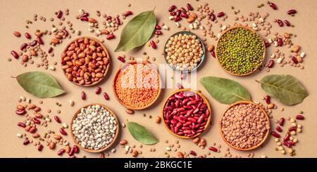 Assortiment de légumineuses, vue panoramique en hauteur sur fond brun. Lentilles, soja, pois chiches, haricots rouges, pois à oei noir, vatiété des légumineuses Banque D'Images