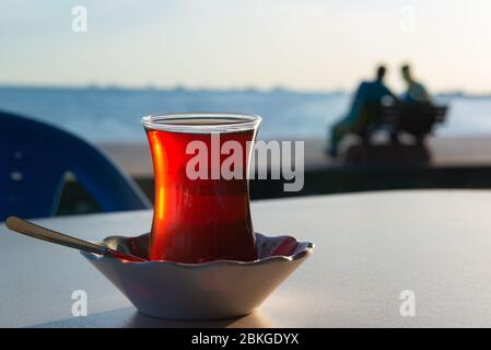 Un verre de thé servi dans le style turc Bosporus Bay vue sur le coucher du soleil Banque D'Images