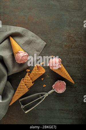 Des pelles à glace aux fruits, en forme de cornets de gaufres, avec un ustensile argenté Banque D'Images