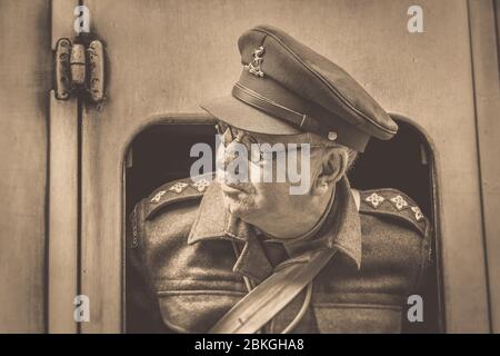 Sépia près de l'homme des années 1940 en tant qu'officier de la Garde d'accueil Capitaine Mainwaring (Arthur Lowe lookeking) regardant hors de la fenêtre de train vintage Severn Valley Railway. Banque D'Images