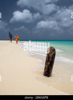 Deux personnes marchant main dans la main le long d'une plage d'Eagle. Aruba, Antilles néerlandaises, Caraïbes Banque D'Images