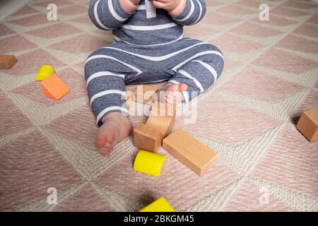 Un tout-petit jouant avec des blocs de jeu en bois dans leur pépinière tiré de la tête Banque D'Images