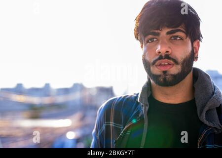 Face de jeune homme indien barbu avec vue sur la ville Banque D'Images