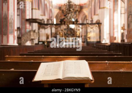Bible autour des bancs sur fond d'autel dans l'église catholique Banque D'Images