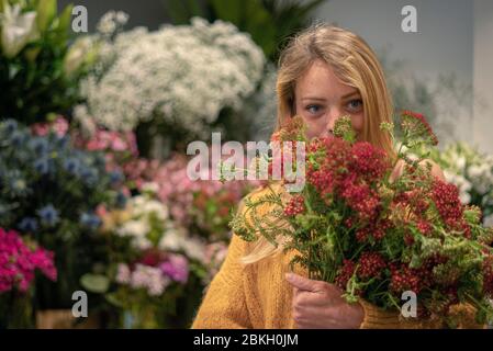 Jeune femme debout dans un fleuriste Banque D'Images