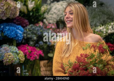 Jeune femme debout dans un fleuriste Banque D'Images