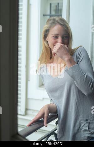 Jeune femme se penchant contre les rambardes Banque D'Images