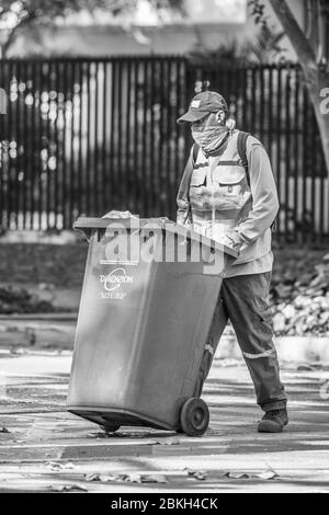 Travailleur de nettoyage immigrant inquiet en travaillant sur les rues de Santiago nettoyage pendant l'infection à coronavirus COVID-19 avec protection précaire Banque D'Images