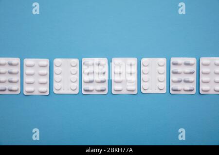 Collection de comprimés médicaux et de comprimés sur un fond bleu vif Banque D'Images