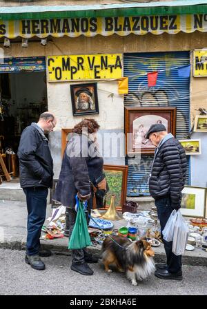 Les chasseurs de bonnes affaires ont fait le tour des antiquités et de la brac-a-brac en vente sur le marché aux puces de Rastro entre la Latina et Embajadores, Madrid, Espagne. Banque D'Images