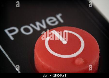 Macro extrême d'un bouton d'alimentation rouge sur une télécommande pour un téléviseur Banque D'Images