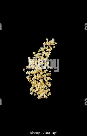 Popcorn préparé volant isolé sur fond noir, Banque D'Images