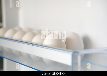 Œufs de poulet frais blancs provenant du réfrigérateur. Œufs sur la tablette du réfrigérateur. Stockage des produits à domicile. Banque D'Images