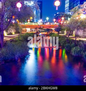 Un canal d'eau qui coule à travers une ville reflétant des couleurs vives sur sa surface et des lanternes chinoises suspendues au-dessus de la ville de Séoul, au sud de Kore Banque D'Images
