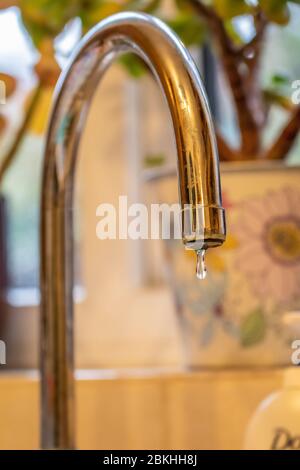 Robinet chromé qui s'égoutte pour laisser l'eau s'écouler Banque D'Images