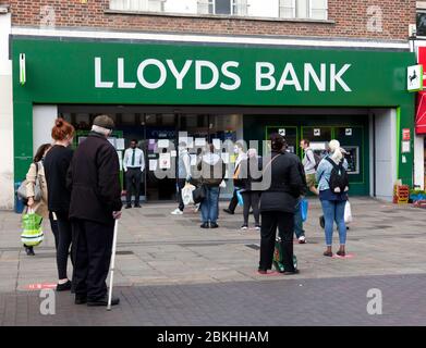 Les membres du public observent les distances sociales, tout en faisant patiemment la queue pour entrer dans la Lloyds Bank à Lewisham High-Street, lors du verrouillage COVID-19 Banque D'Images