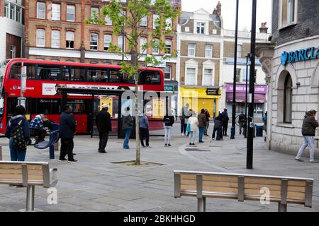 Les membres du public observent les distances sociales, tout en faisant la queue pour entrer dans la Barclays Bank à Lewisham High-Street, pendant le verrouillage COVID-19 Banque D'Images