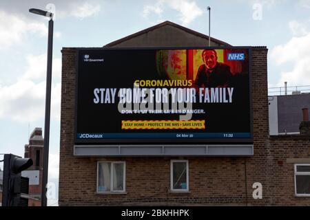 Un panneau publicitaire numérique commercial JC Decaux, situé au coin de Rennell Street, à Lewisham, portant une publicité du gouvernement britannique préconisant le maintien à domicile, la protection du NHS et le sauvetage de vies, pendant le programme de verrouillage du coronavirus Banque D'Images