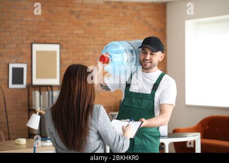 Femme recevant de l'eau du service de messagerie au bureau Banque D'Images