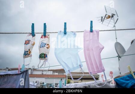 Jeu de masques lavables suspendus sur une ligne de linge. L'ensemble représente la famille contre le covid-19 Banque D'Images