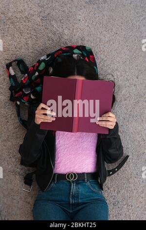 Un étudiant de l'université lit sur le sol Banque D'Images