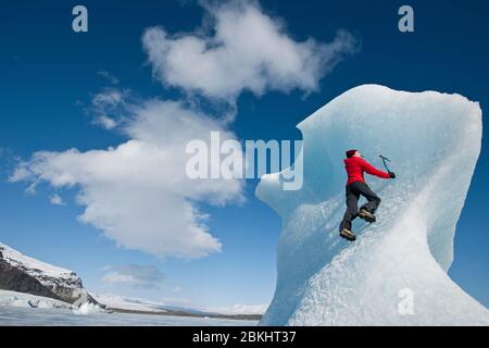 Femme grimpez l'iceberg sur le lagon du glacier de Fjallsjoull Banque D'Images