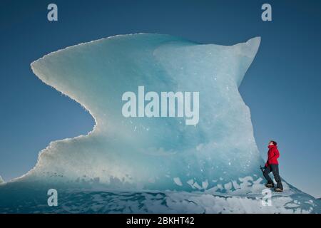 Femme grimpez l'iceberg sur le lagon du glacier de Fjallsjoull Banque D'Images