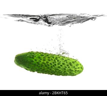 Chute de concombre frais dans l'eau sur fond blanc Banque D'Images
