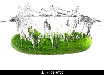 Chute de concombre frais dans l'eau sur fond blanc Banque D'Images