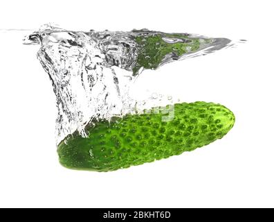 Chute de concombre frais dans l'eau sur fond blanc Banque D'Images