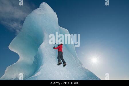 Femme grimpez l'iceberg sur le lagon du glacier de Fjallsjoull Banque D'Images